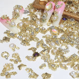 50 Stück Charms per unghie in oro, stili misti Glitzersteine ​​​​Nägel Perle Legierung Nagel Steine ​​​​Blume Schmetterling Strasssteine ​​​​Nägel Herz Stern Nagel Charms DIY Nail Art Zubehör Frauen Nägel Deko