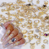 50 Stück Charms per unghie in oro, stili misti Glitzersteine ​​​​Nägel Perle Legierung Nagel Steine ​​​​Blume Schmetterling Strasssteine ​​​​Nägel Herz Stern Nagel Charms DIY Nail Art Zubehör Frauen Nägel Deko